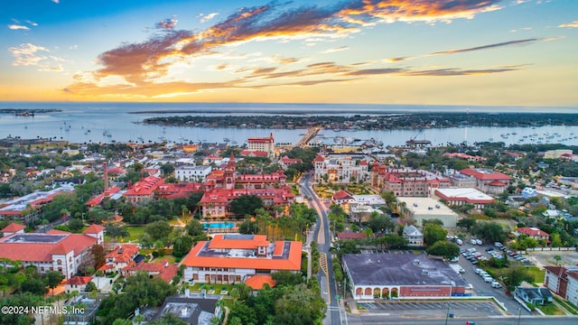 aerial view at dusk featuring a water view