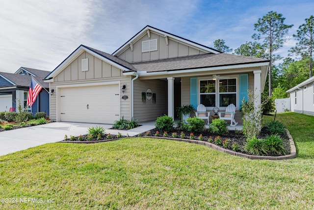 view of front of house featuring covered porch, a garage, and a front yard