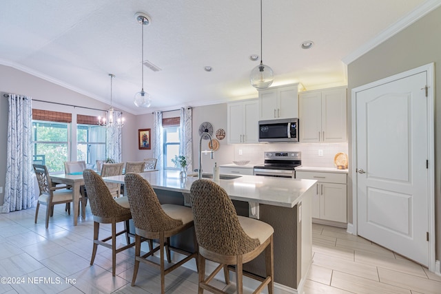 kitchen featuring hanging light fixtures, a center island with sink, white cabinets, and stainless steel appliances