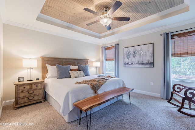 carpeted bedroom featuring ceiling fan, crown molding, and a tray ceiling