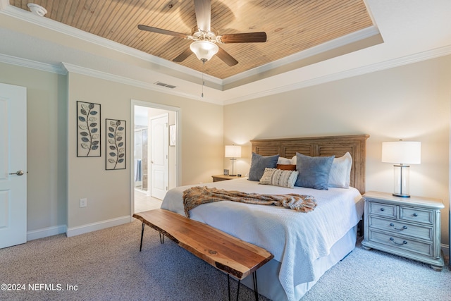 carpeted bedroom featuring ceiling fan, crown molding, connected bathroom, and a tray ceiling