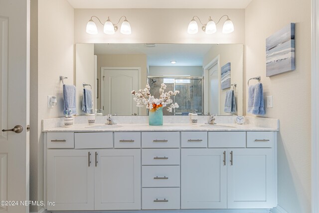 bathroom with vanity and a shower with door