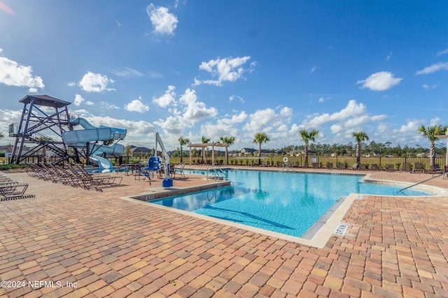 view of pool featuring a patio area and a water slide