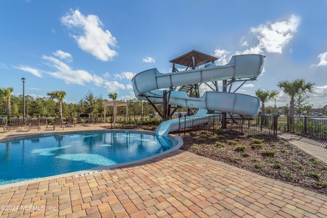 view of swimming pool featuring a patio and a water slide