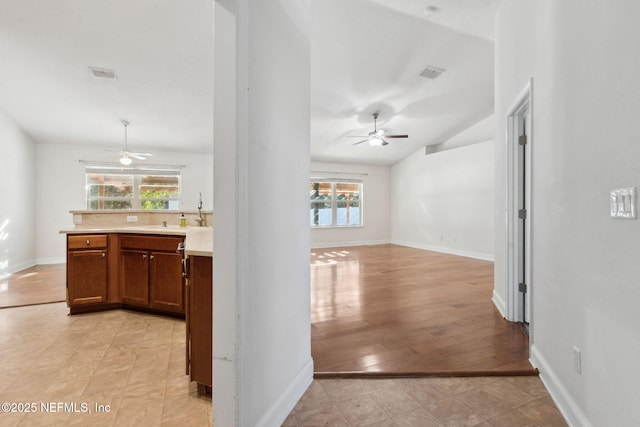 hallway with light hardwood / wood-style flooring and vaulted ceiling