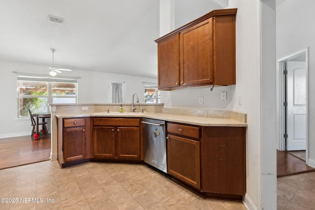 kitchen featuring kitchen peninsula, stainless steel dishwasher, vaulted ceiling, ceiling fan, and sink