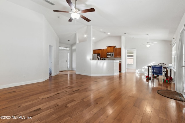 living room featuring ceiling fan, hardwood / wood-style floors, and high vaulted ceiling