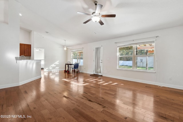 unfurnished living room featuring ceiling fan, wood-type flooring, and vaulted ceiling