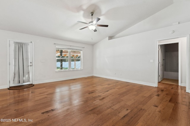 spare room featuring wood-type flooring, vaulted ceiling, and ceiling fan