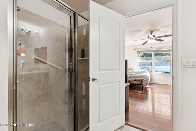 bathroom featuring an enclosed shower, hardwood / wood-style floors, and ceiling fan