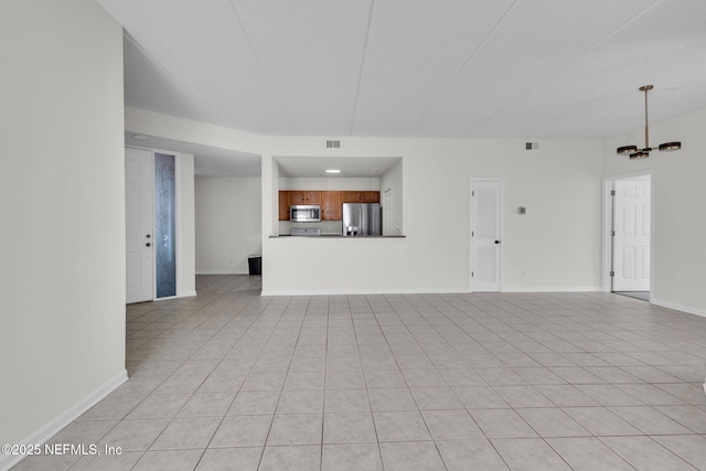 unfurnished living room with light tile patterned flooring and an inviting chandelier