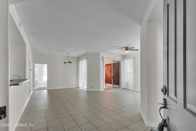 tiled empty room featuring ceiling fan and a wealth of natural light