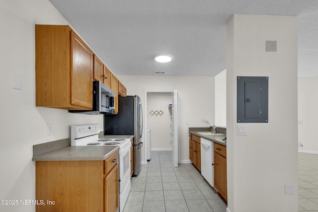 kitchen featuring light tile patterned floors, white appliances, sink, and electric panel