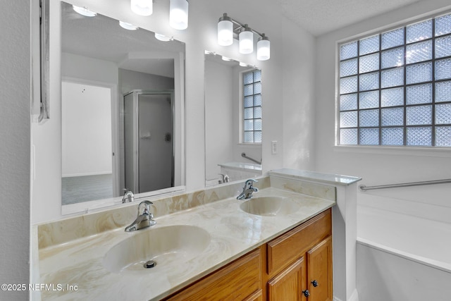 bathroom featuring vanity, an enclosed shower, and a textured ceiling