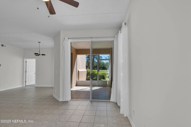 spare room featuring ceiling fan and light tile patterned floors