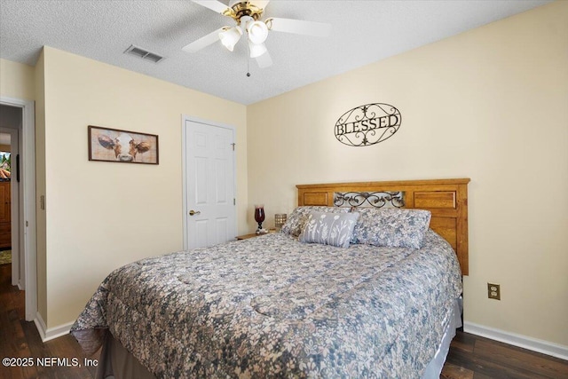 bedroom featuring ceiling fan, dark wood-type flooring, and a textured ceiling