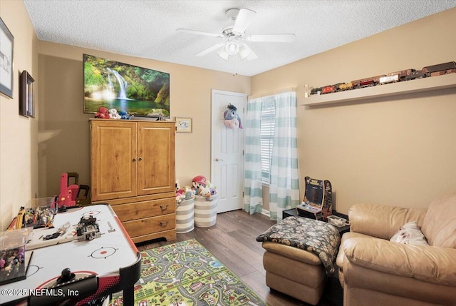 interior space with ceiling fan, light wood-type flooring, and a textured ceiling