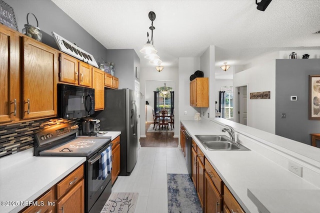 kitchen featuring black appliances, sink, decorative backsplash, a textured ceiling, and decorative light fixtures