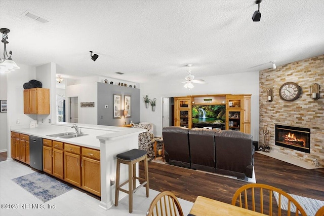 kitchen with a textured ceiling, decorative light fixtures, ceiling fan, and black dishwasher