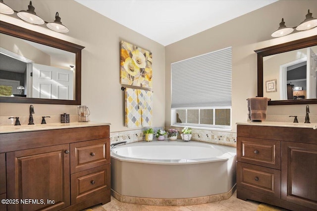 bathroom with a tub, tile patterned flooring, and vanity