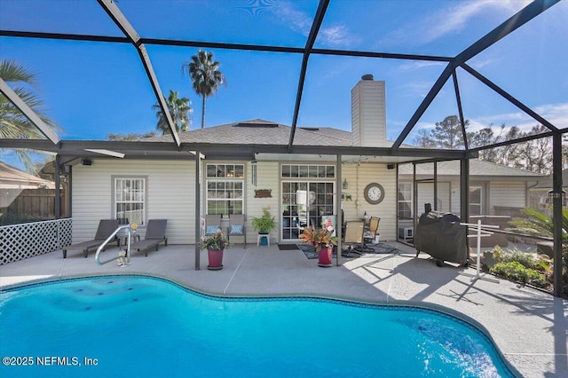 view of swimming pool featuring a patio and glass enclosure