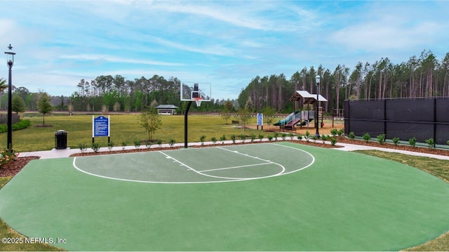 view of sport court with a playground and a lawn