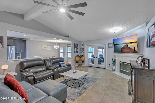 tiled living room featuring a high end fireplace, french doors, a textured ceiling, ceiling fan with notable chandelier, and vaulted ceiling with beams