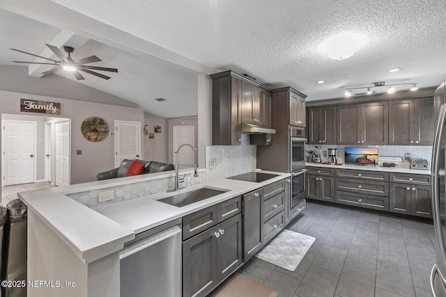 kitchen featuring backsplash, sink, vaulted ceiling with beams, a textured ceiling, and stainless steel appliances