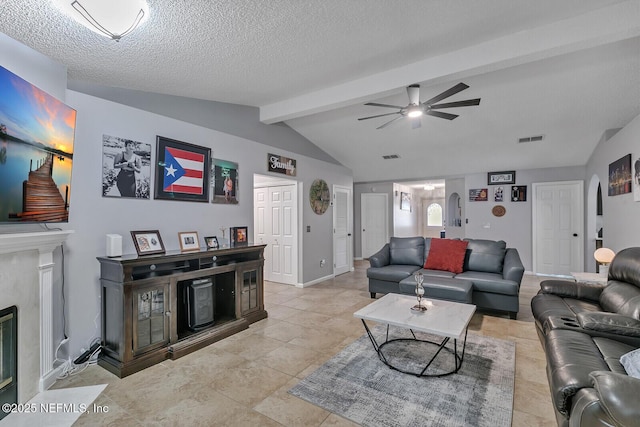 tiled living room with vaulted ceiling with beams, ceiling fan, a high end fireplace, and a textured ceiling