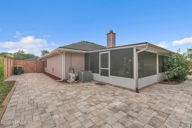 back of property with a patio, central AC unit, and a sunroom