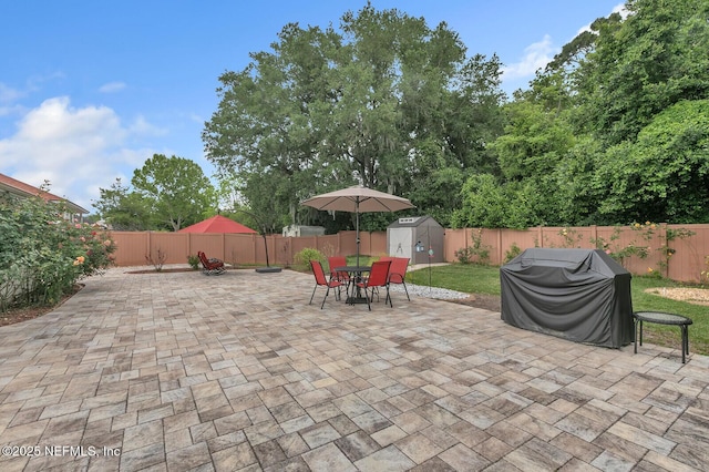 view of patio featuring a shed and area for grilling