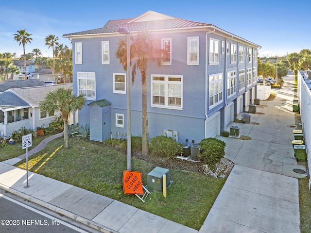 view of property exterior featuring a yard, a garage, and cooling unit