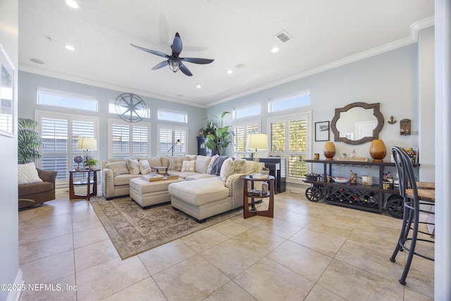 tiled living room with a textured ceiling, ceiling fan, and ornamental molding