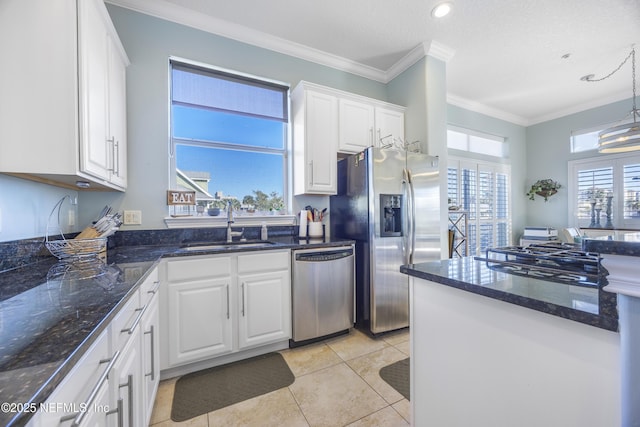 kitchen with appliances with stainless steel finishes, sink, light tile patterned floors, decorative light fixtures, and white cabinetry