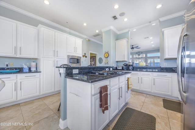 kitchen with light tile patterned flooring, ceiling fan, white cabinets, and stainless steel appliances