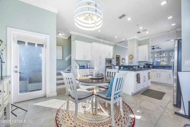 dining space featuring ceiling fan, crown molding, and light tile patterned flooring