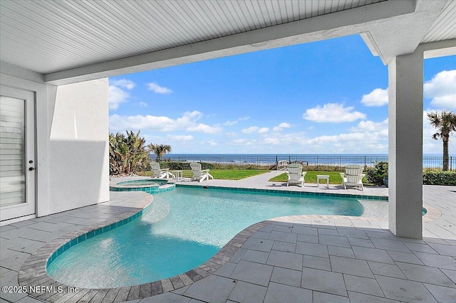 view of pool featuring an in ground hot tub, a water view, and a patio