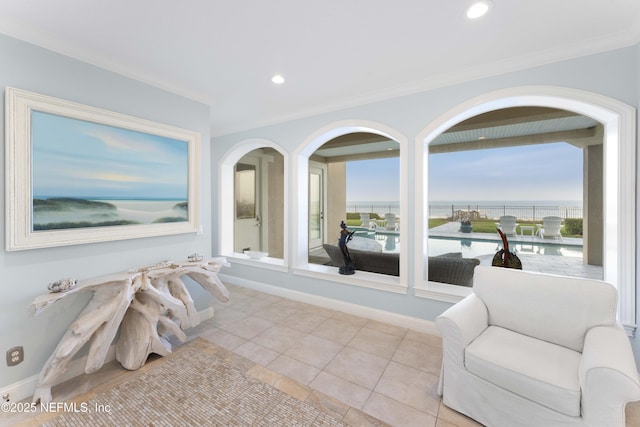 interior space with light tile patterned floors, a water view, a wealth of natural light, and crown molding