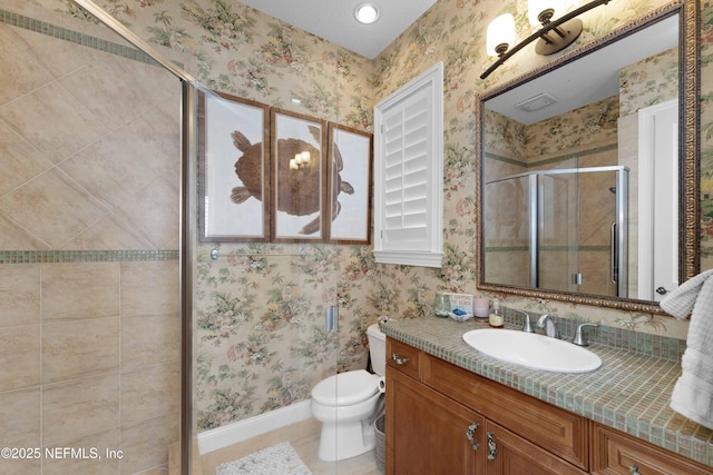 bathroom featuring tile patterned floors, vanity, toilet, and a shower with door