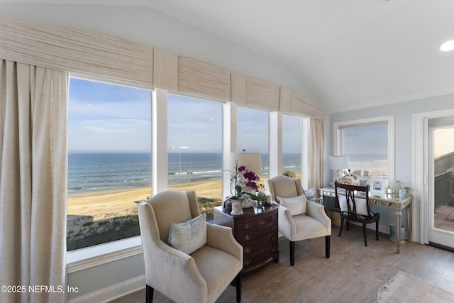 sunroom featuring a beach view, a water view, and lofted ceiling