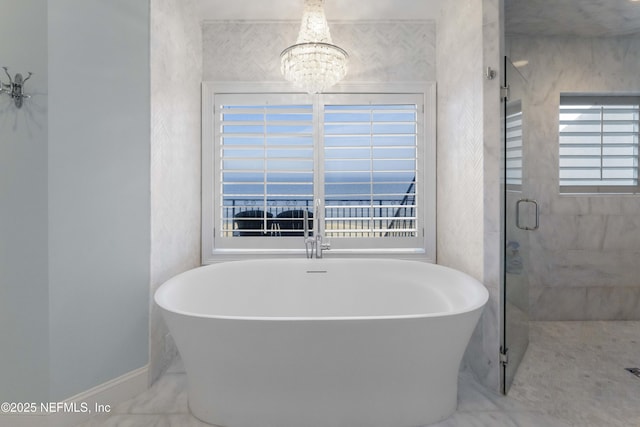 bathroom featuring plus walk in shower and an inviting chandelier