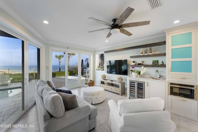 tiled living room featuring ornamental molding, ceiling fan, sink, a water view, and wine cooler