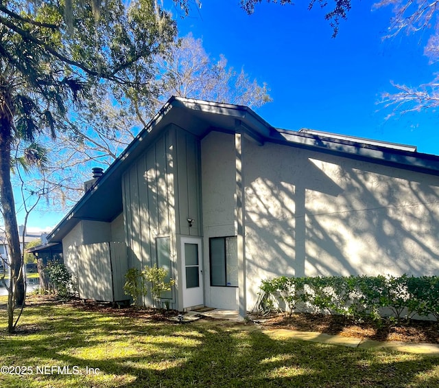 view of side of home with a yard