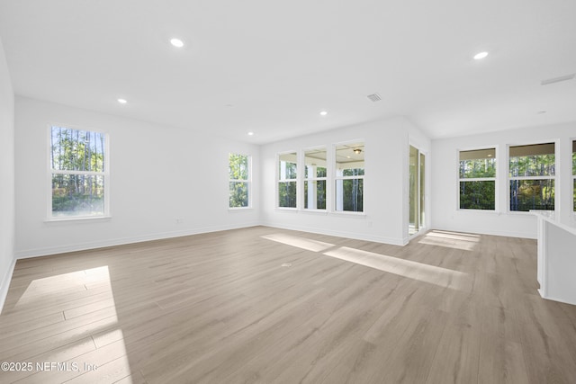 unfurnished living room with light hardwood / wood-style floors and a wealth of natural light