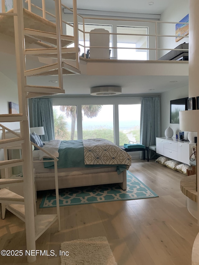 bedroom with hardwood / wood-style flooring and a towering ceiling