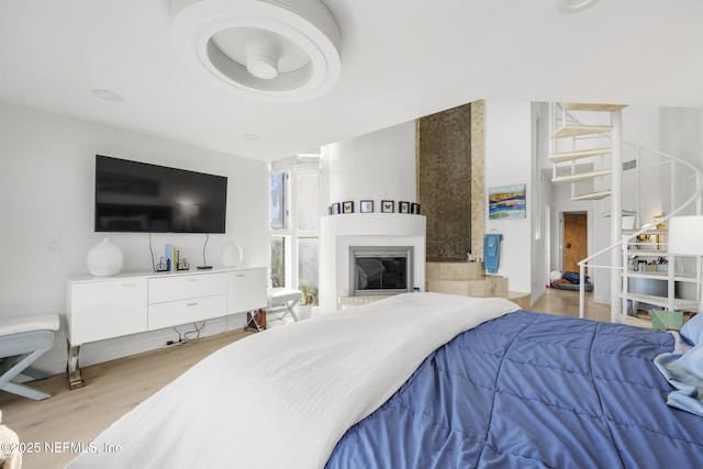 bedroom featuring light hardwood / wood-style flooring and a large fireplace