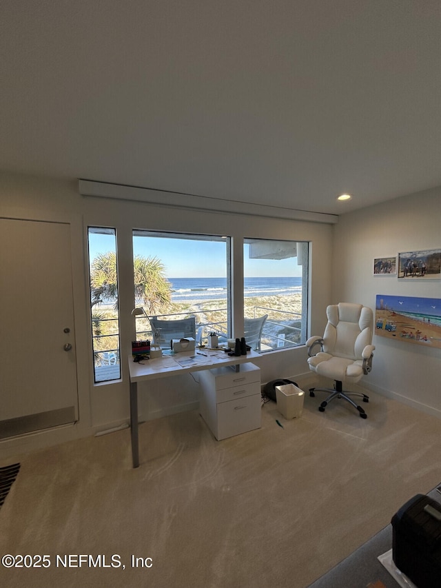 unfurnished office featuring a water view and light colored carpet