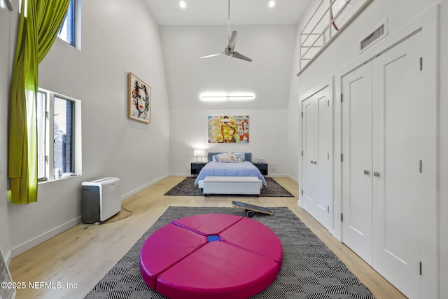 bedroom with multiple windows, light hardwood / wood-style flooring, and a closet