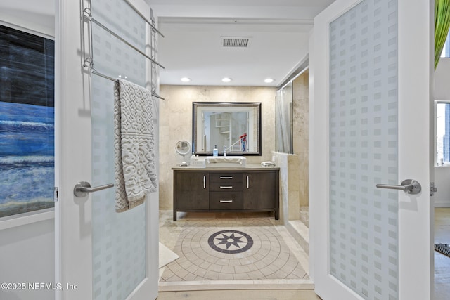 bathroom featuring vanity, tile patterned floors, and walk in shower