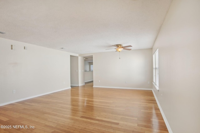 empty room featuring ceiling fan, light hardwood / wood-style floors, and a textured ceiling